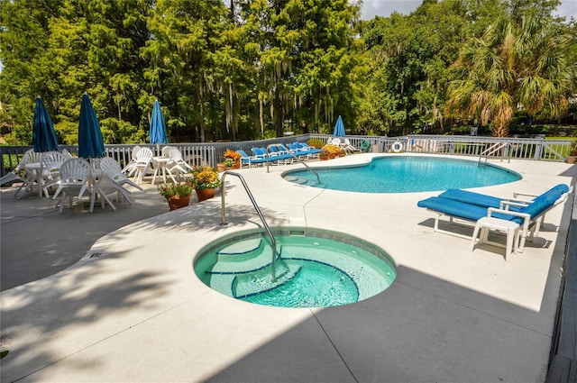 community pool featuring fence, a community hot tub, and a patio