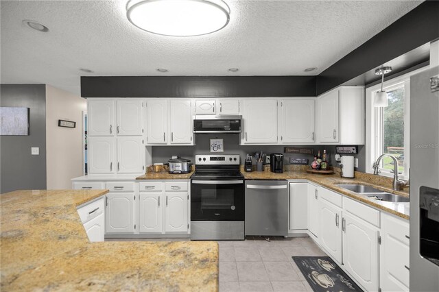 1081 SE 170th Ave, Silver Springs, FL 34488 - kitchen featuring appliances with stainless steel finishes, a sink, white cabinetry, a textured ceiling, and light countertops