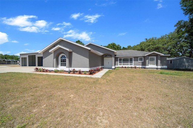 ranch-style home featuring concrete driveway, a front yard, and stucco siding