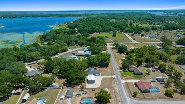 birds eye view of property with a view of trees and a water view
