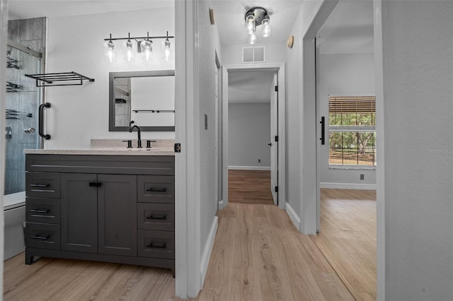 full bath with wood finished floors, visible vents, vanity, and a stall shower
