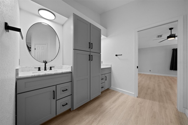 full bath with a ceiling fan, wood finished floors, vanity, baseboards, and visible vents
