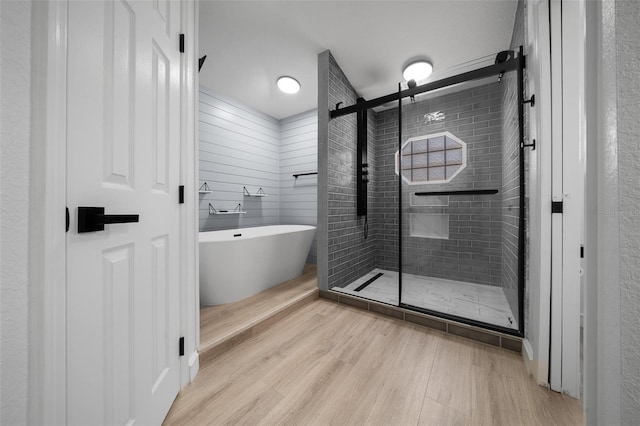 full bathroom with a soaking tub, wood finished floors, and a stall shower