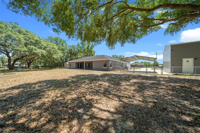 view of yard with fence and a detached carport