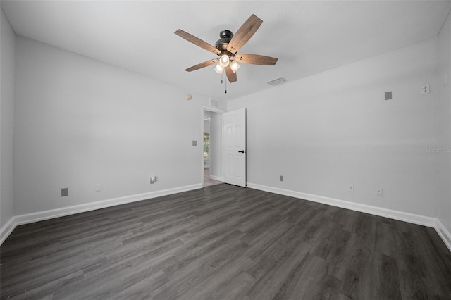 spare room featuring baseboards, visible vents, dark wood-style floors, and ceiling fan