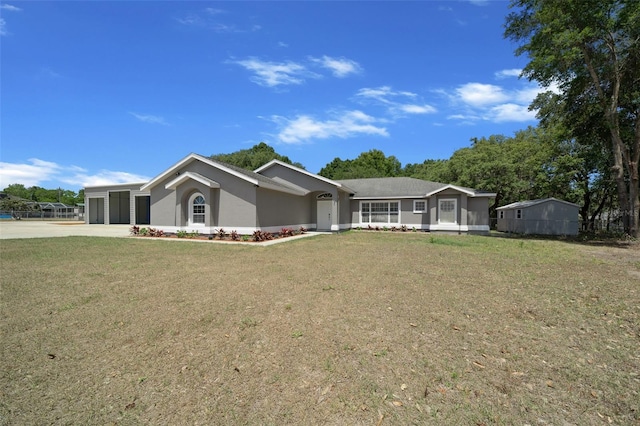 ranch-style home with an attached garage, a front yard, stucco siding, and driveway