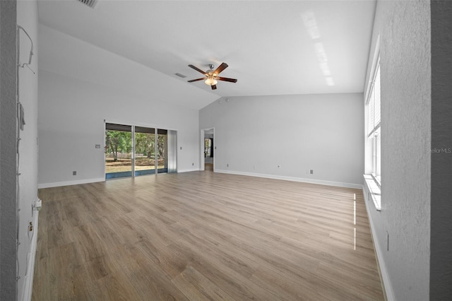 unfurnished living room with vaulted ceiling, light wood-style floors, ceiling fan, baseboards, and visible vents