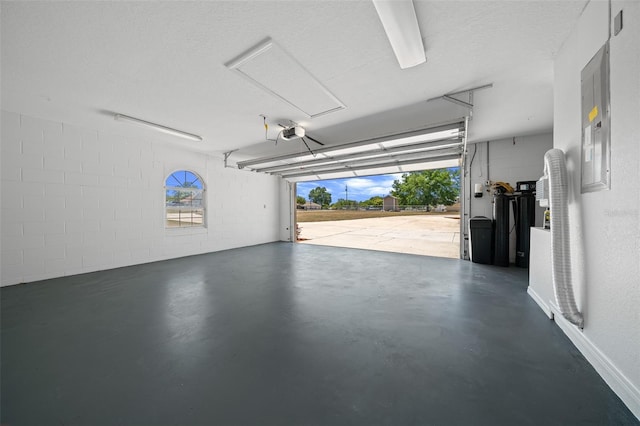 garage featuring concrete block wall and a garage door opener