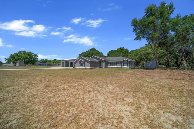 view of yard featuring fence, concrete driveway, an outbuilding, a storage unit, and a garage