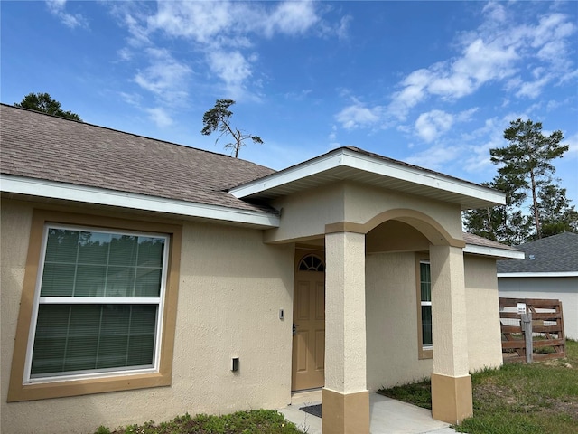 15976 SW 23rd Court Rd, Ocala, FL 34473 - entrance to property featuring a shingled roof, fence, and stucco siding