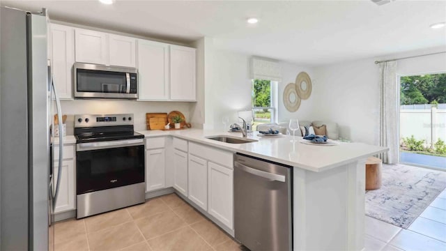 6591 SW 81st Loop, Ocala, FL 34476 - kitchen featuring stainless steel appliances, a peninsula, a sink, recessed lighting, and white cabinetry