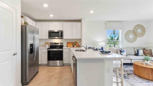 6591 SW 81st Loop, Ocala, FL 34476 - kitchen with stainless steel appliances, a sink, a peninsula, a kitchen bar, and open floor plan
