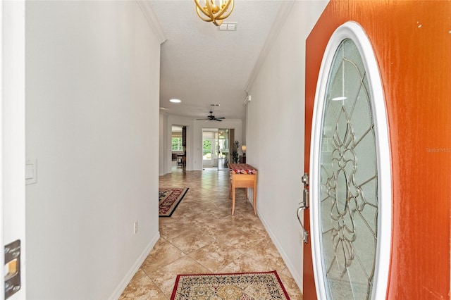 foyer entrance with crown molding, baseboards, and ceiling fan