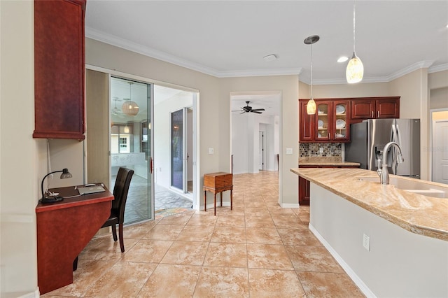 kitchen featuring stainless steel fridge with ice dispenser, a sink, crown molding, pendant lighting, and glass insert cabinets