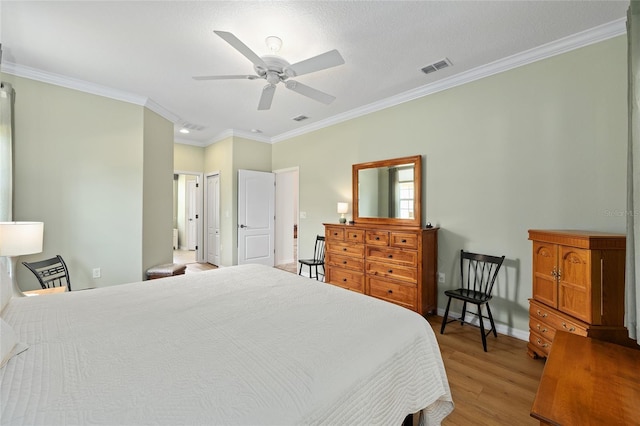 bedroom with a ceiling fan, crown molding, light wood-style floors, baseboards, and visible vents