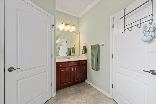 bathroom featuring baseboards, vanity, tile patterned floors, and crown molding