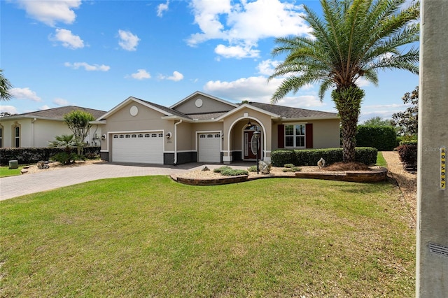 single story home with a garage, stucco siding, a front yard, and decorative driveway