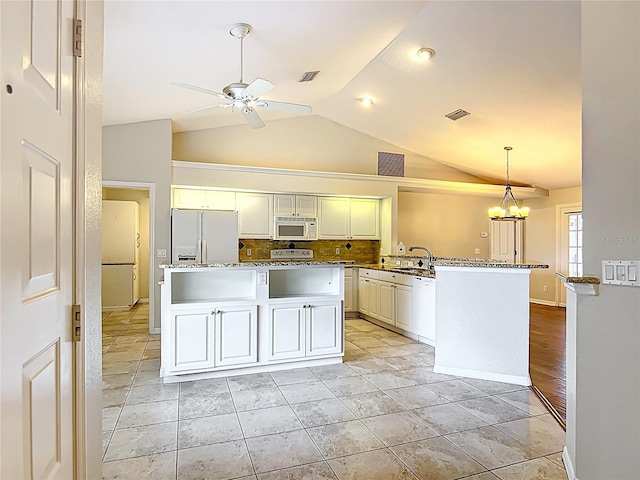 5327 SW 89th St, Ocala, FL 34476 - kitchen with a sink, white appliances, ceiling fan with notable chandelier, decorative backsplash, and lofted ceiling