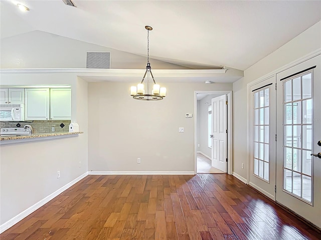 5327 SW 89th St, Ocala, FL 34476 - unfurnished dining area with visible vents, a chandelier, vaulted ceiling, and wood finished floors