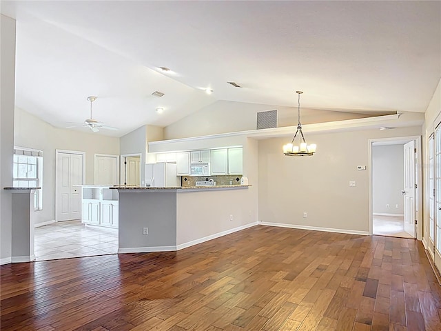 5327 SW 89th St, Ocala, FL 34476 - kitchen with white appliances, ceiling fan with notable chandelier, a peninsula, wood finished floors, and lofted ceiling
