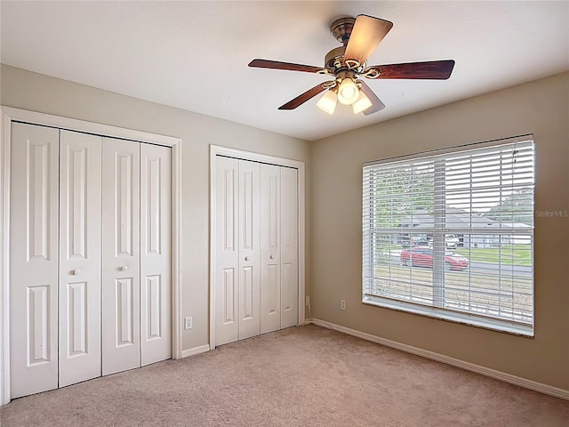 5327 SW 89th St, Ocala, FL 34476 - unfurnished bedroom with baseboards, a ceiling fan, multiple closets, and light carpet