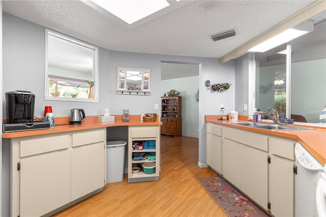 10989 SW 86th Ave, Ocala, FL 34481 - kitchen with light countertops, dishwasher, light wood-style flooring, and a sink