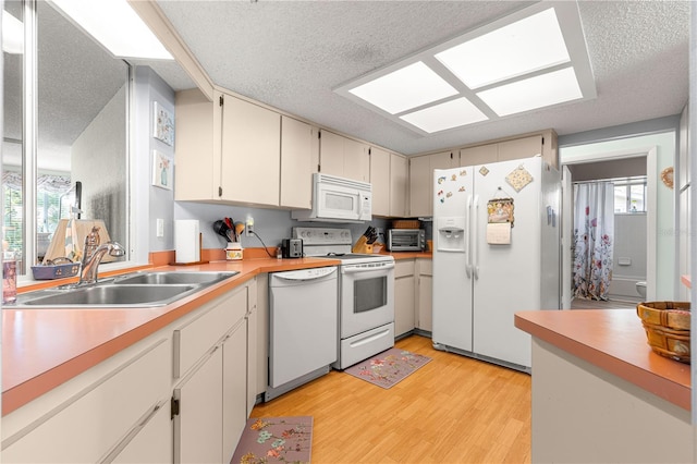 10989 SW 86th Ave, Ocala, FL 34481 - kitchen with a sink, light wood-style floors, white appliances, light countertops, and a textured ceiling