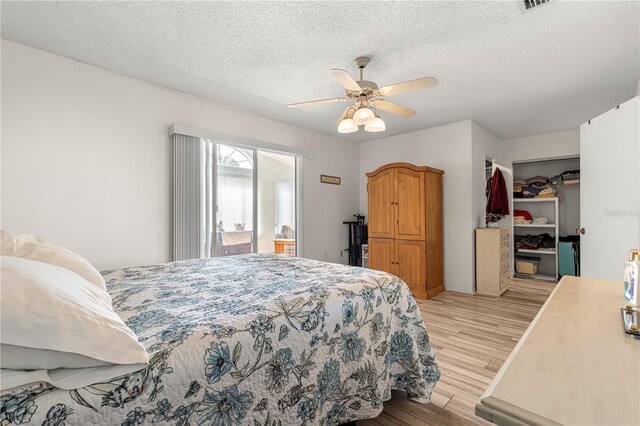 10989 SW 86th Ave, Ocala, FL 34481 - bedroom featuring light wood-style flooring, a closet, a spacious closet, a ceiling fan, and a textured ceiling