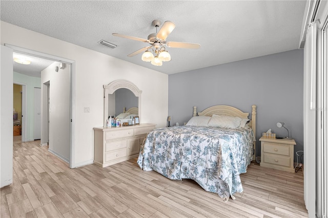 10989 SW 86th Ave, Ocala, FL 34481 - bedroom with visible vents, a ceiling fan, a textured ceiling, and light wood finished floors