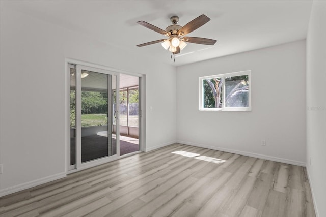 spare room featuring plenty of natural light, baseboards, and wood finished floors