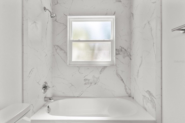 bathroom with washtub / shower combination and toilet