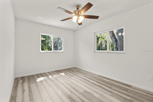 empty room with baseboards, a ceiling fan, and wood finished floors