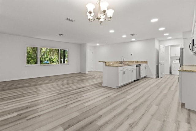 kitchen featuring a sink, dishwasher, washer / clothes dryer, visible vents, and recessed lighting