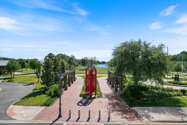 view of home's community with a lawn and a water view