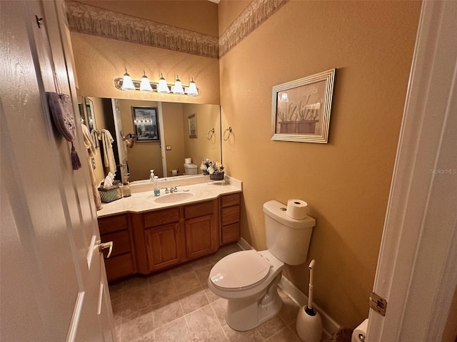 bathroom featuring baseboards, toilet, vanity, and tile patterned floors