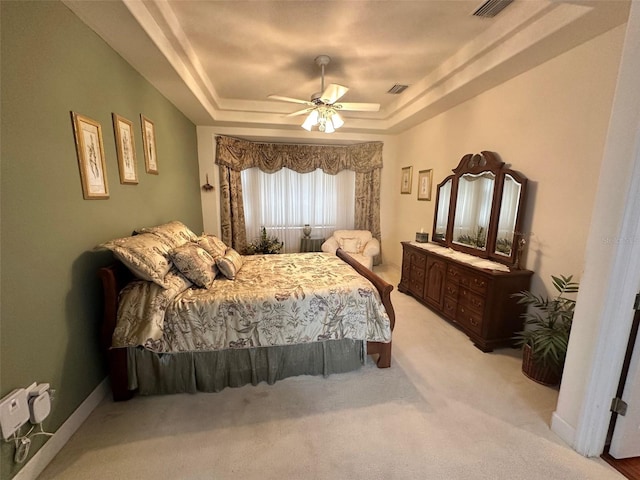 bedroom featuring light colored carpet, ceiling fan, visible vents, and a raised ceiling
