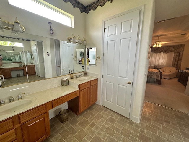 ensuite bathroom with brick patterned floor, ensuite bath, and a sink