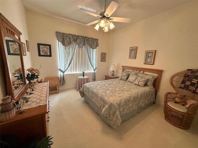bedroom featuring light colored carpet, ceiling fan, and baseboards