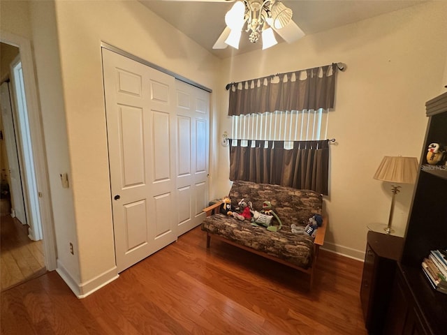 sitting room featuring baseboards, a ceiling fan, and wood finished floors