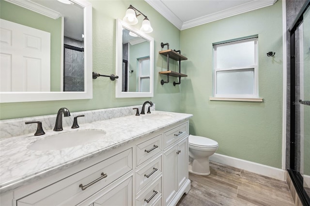 full bath with a sink, crown molding, toilet, and wood finished floors