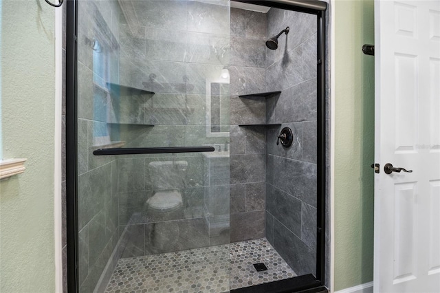 full bathroom featuring a stall shower and a textured wall