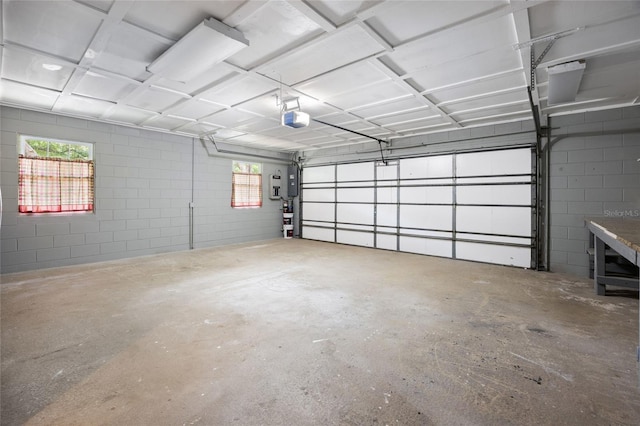 garage with concrete block wall and a garage door opener