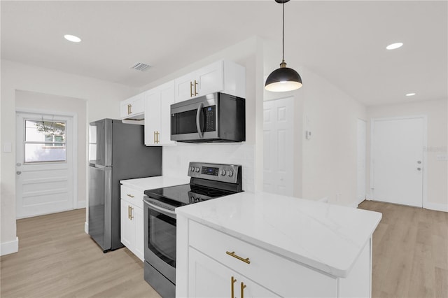 3807 SW 143rd Lane Rd, Ocala, FL 34473 - kitchen featuring appliances with stainless steel finishes, light wood finished floors, white cabinetry, pendant lighting, and recessed lighting