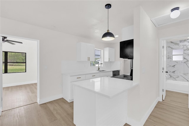 3807 SW 143rd Lane Rd, Ocala, FL 34473 - kitchen featuring a sink, light wood finished floors, white cabinets, and light countertops