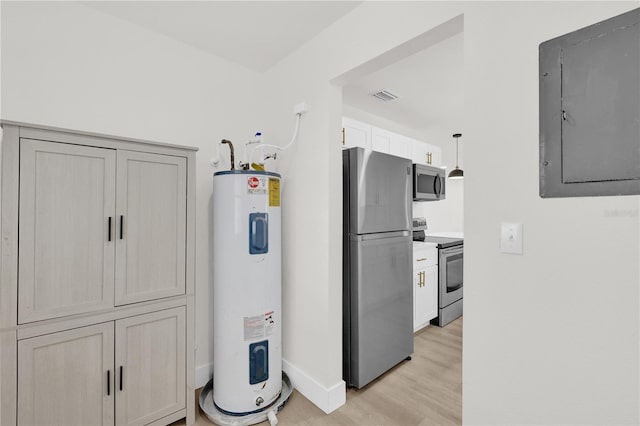 3807 SW 143rd Lane Rd, Ocala, FL 34473 - kitchen with appliances with stainless steel finishes, water heater, electric panel, light wood-style floors, and baseboards