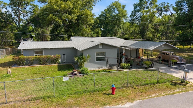 ranch-style house featuring a fenced backyard, a front lawn, stucco siding, and an attached carport