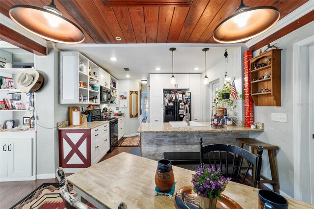 kitchen featuring black appliances, a peninsula, open shelves, and a sink