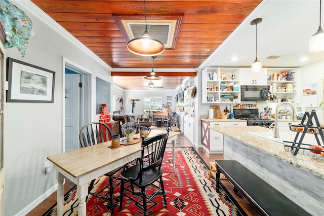 dining space featuring visible vents, baseboards, wood finished floors, crown molding, and wooden ceiling