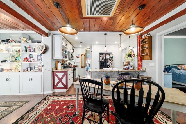dining area with wood ceiling, visible vents, and light wood-style floors