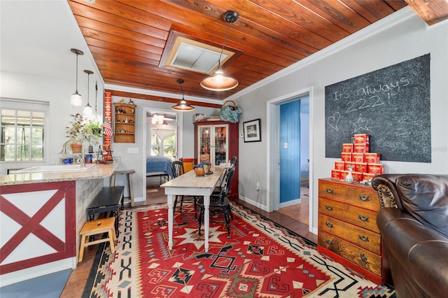 dining room featuring wooden ceiling, wood finished floors, ornamental molding, and a healthy amount of sunlight